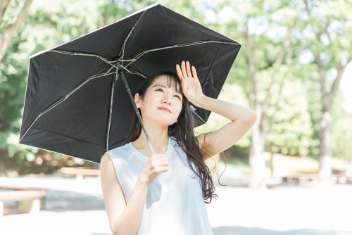 紫外線を気にして日傘をさす女性