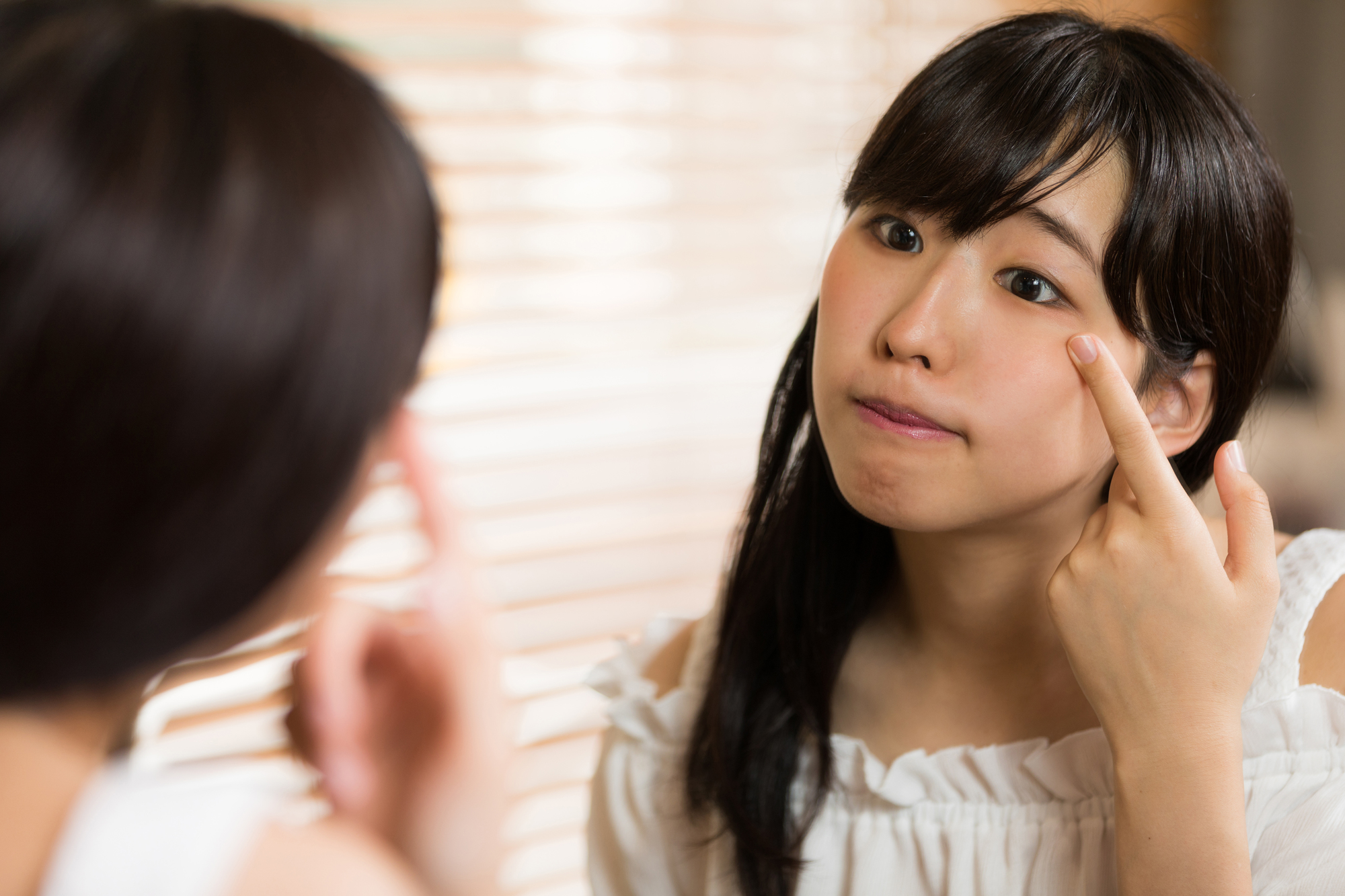 腫れぼったいまぶたを気にする女性