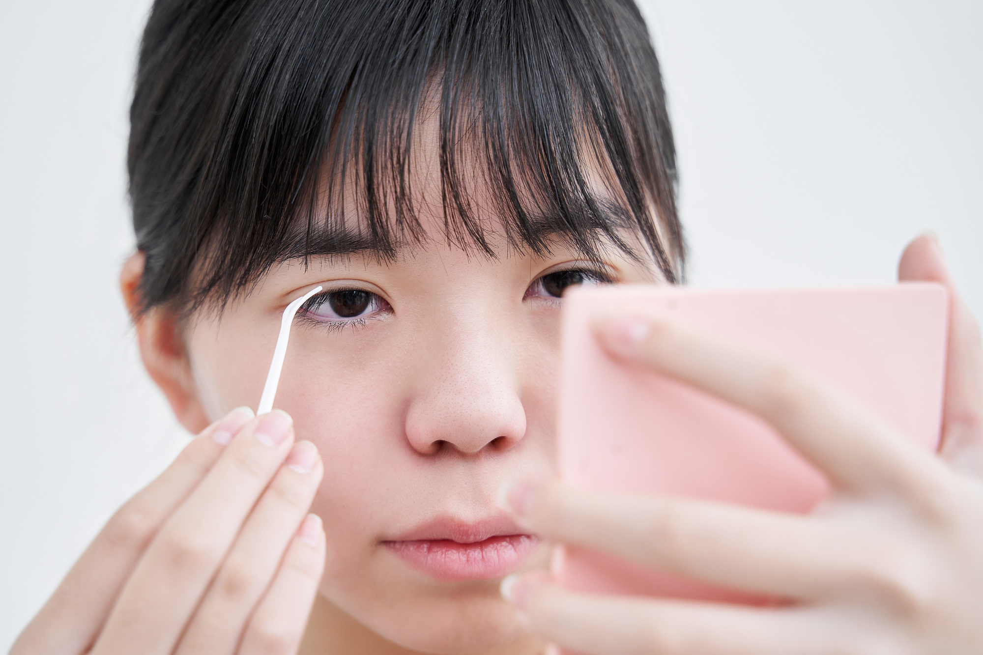 目を大きく見せようと工夫している女性